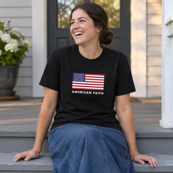 The American Flag Tee in black, worn on a front porch